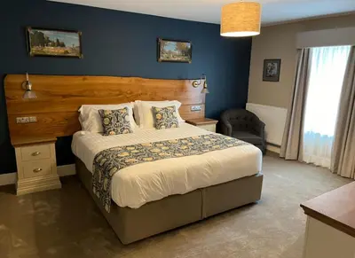 a bedroom with a large bed and a blue wall at The Castle Coaching Inn in Trecastle