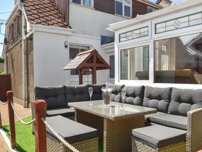 a patio with a table and a couches and a table and a tableablish at Ferwig in New Quay