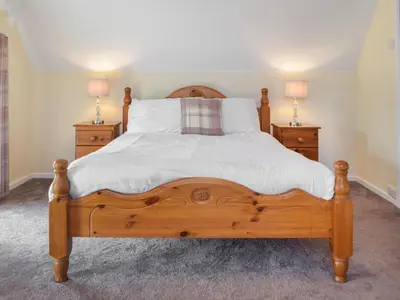 a bedroom with a wooden bed with two night stands at Ferwig in New Quay