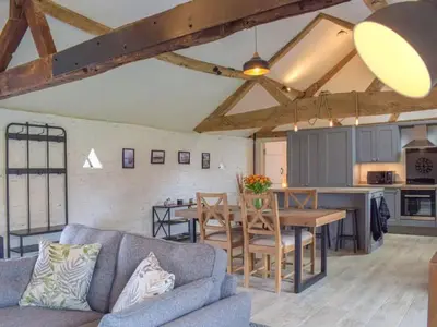 a living room with a couch and a table at Castle Beams in Craven Arms