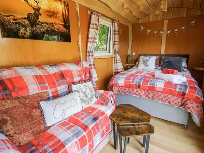 a room with two beds and a couch in a cabin at Shepherd's Cwtch in Llandovery