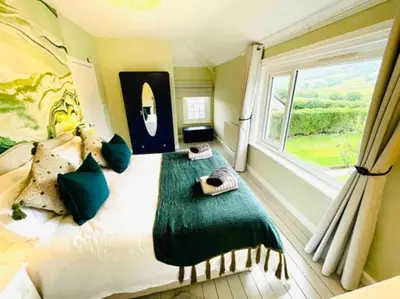 a bedroom with a large bed with a window at Awelfa a peaceful cottage in the Cambrian mountains in Llanbrynmair