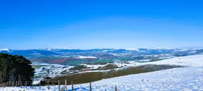 a snow covered mountain with a view of a valley at Awelfa a peaceful cottage in the Cambrian mountains in Llanbrynmair