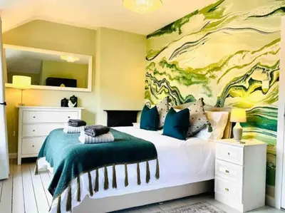 a bedroom with a bed with a painting on the wall at Awelfa a peaceful cottage in the Cambrian mountains in Llanbrynmair