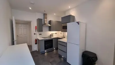 a kitchen with a white refrigerator and a stove at Abergwaun APT 1 in Aberystwyth