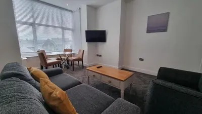 a living room with a couch and a table at Abergwaun APT 1 in Aberystwyth