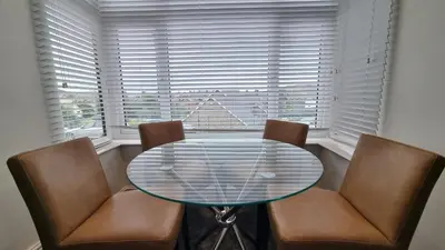 a dining room with a glass table and two chairs at Abergwaun APT 1 in Aberystwyth