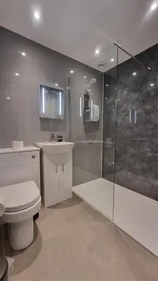 a bathroom with a shower and a toilet and a sink at Abergwaun Apt 2 in Aberystwyth