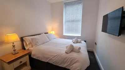 a bedroom with a bed with two towels on it at Abergwaun Apt 2 in Aberystwyth