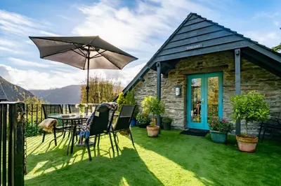 a patio with a table and an umbrella at Tollant in Rhayader