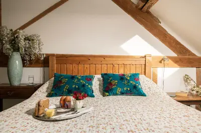 a bed with a tray of food on it at Tollant in Rhayader