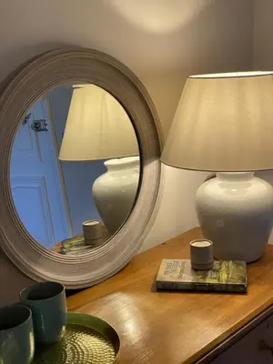 a table with a mirror and a lamp on a table at Maes Y Neuadd Country House in Talsarnau