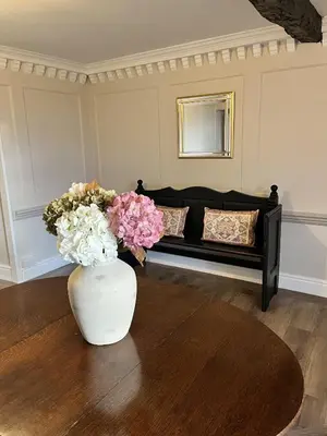 a living room with a couch and a vase with flowers at Maes Y Neuadd Country House in Talsarnau