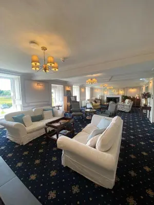 a large living room with white couches and tables at Maes Y Neuadd Country House in Talsarnau