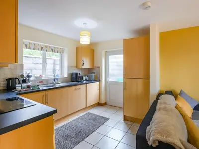 a living room with a couch and a kitchen at High Tide in Scyborycoed