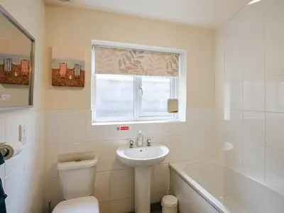 a bathroom with a sink and a toilet and a tub at High Tide in Scyborycoed