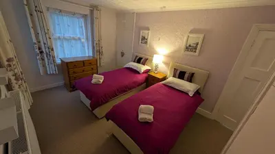 two beds in a room with red sheets at Synod Farm Cottage, 5 Person Hot Tub, Pets Welcome in Llandysul