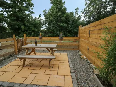 a picnic table in a backyard with a wooden fence at Garden View in Llanybydder