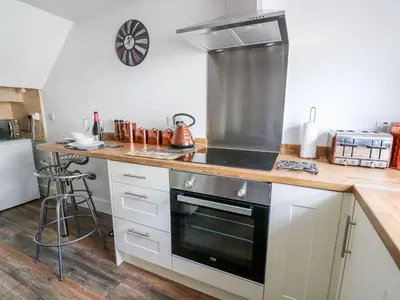 a kitchen with white cabinets and a stove top oven at Field View in Llanybydder