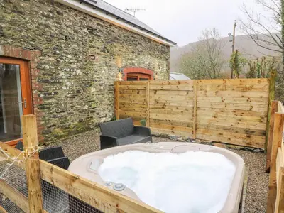 a jacuzzi tub in the backyard of a house at Field View in Llanybydder