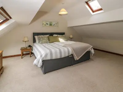 a bedroom with a large bed in a attic at Pennant Tigi Uchaf in Dolgellau
