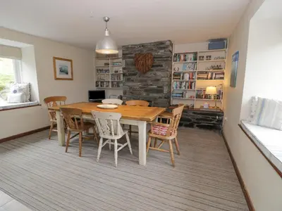 a dining room with a wooden table and chairs at Pennant Tigi Uchaf in Dolgellau