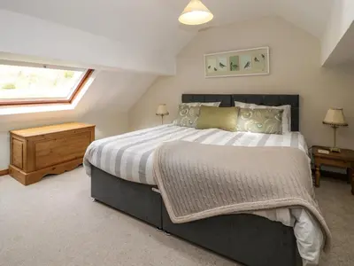 a bedroom with a large bed and a window at Pennant Tigi Uchaf in Dolgellau