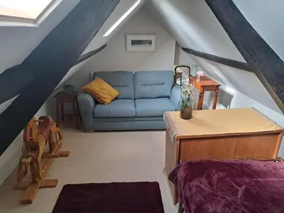 a living room with a blue couch in a attic at Ty Gwyn Farmhouse in Brecon