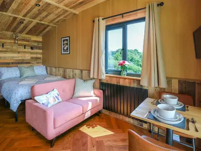 a living room with a couch and a bed at Hen's Hideaway in Saint Harmon