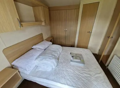 a large bed in a small room with at Cozy 2 Bedroom Static Caravan in Clarach Bay , Aberystwyth in Aberystwyth