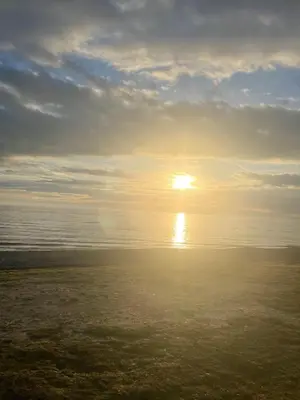 a sunset over the ocean with the sun in the sky at Cozy 2 Bedroom Static Caravan in Clarach Bay , Aberystwyth in Aberystwyth