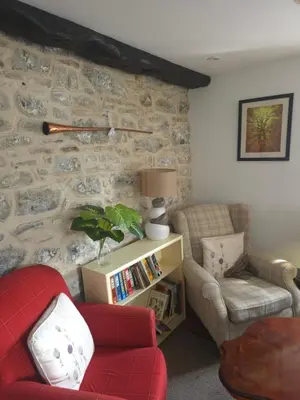 a living room with a couch and a red chair at The Royal Oak Inn, Rhandirmwyn in Rhandirmwyn