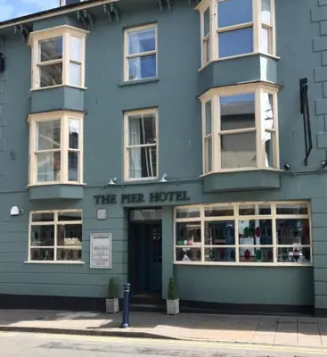 a blue building with the opera hotel on the street at The Pier Hotel in Aberystwyth