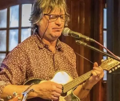 a man playing a guitar in front of a microphone at The Pier Hotel in Aberystwyth
