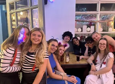 a group of people posing for a picture in a bar at The Pier Hotel in Aberystwyth