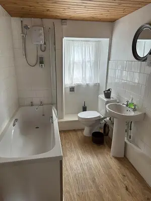 a bathroom with a tub and a toilet and a sink at The Pier Hotel in Aberystwyth