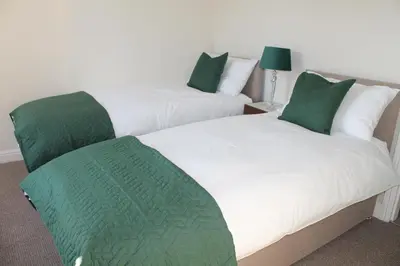 two beds with green pillows in a room at Shrewsbury Georgian town house - Hills Lane in Shrewsbury
