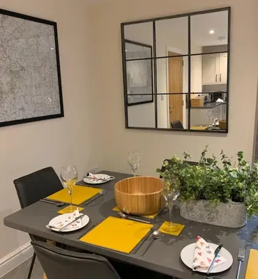 a dining room table with yellow napkins and a mirror at The Stokesay Ludlow in Ludlow