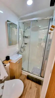 a bathroom with a shower and a toilet and a sink at The Duck House in Barmouth