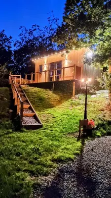 a house with a wooden fence in the grass at The Duck House in Barmouth