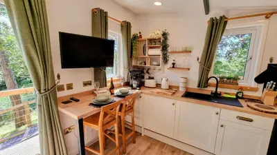 a kitchen with a desk and a tv on the wall at The Duck House in Barmouth