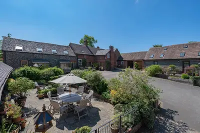 an overhead view of a house with a patio with an umbrella at Gooseyard at Middle Farm and Cottages in Picklescott