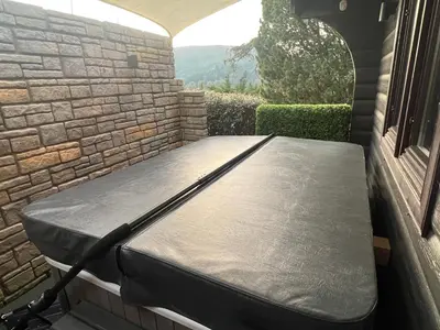 a mattress sitting on a porch next to a window at LARCHES LODGE Norwegian log cabin, wood stove & spa in Church Stretton