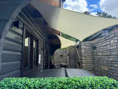 an awning on the side of a house at LARCHES LODGE Norwegian log cabin, wood stove & spa in Church Stretton