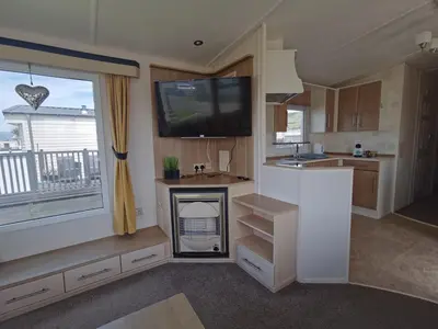 a kitchen with a tv and a fireplace in a caravan at Snowdonia Holiday Sea Beach and Mountains view in Llwyngwril