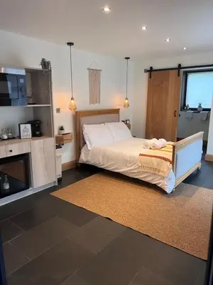 a bedroom with a large bed and a television at Luxury Courtyard Studio in Llangollen in Llangollen