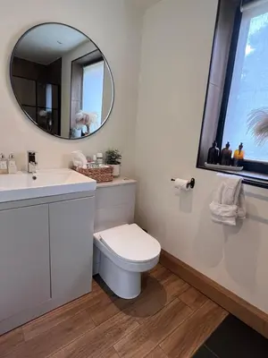 a bathroom with a toilet and a sink and a mirror at Luxury Courtyard Studio in Llangollen in Llangollen
