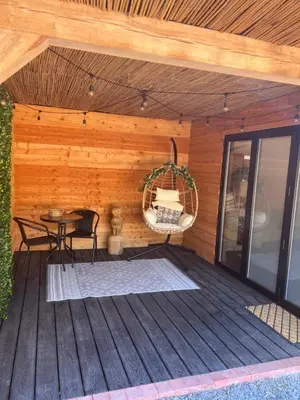 a wooden deck with a table and a wicker basket at Luxury Courtyard Studio in Llangollen in Llangollen