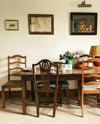 a wooden dining room table with chairs at Garden View Apartment in Oswestry