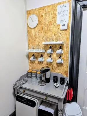 a small kitchen with a stove and a clock on a wall at Family Home in Tywyn - Game and Cinema Rooms in Tywyn